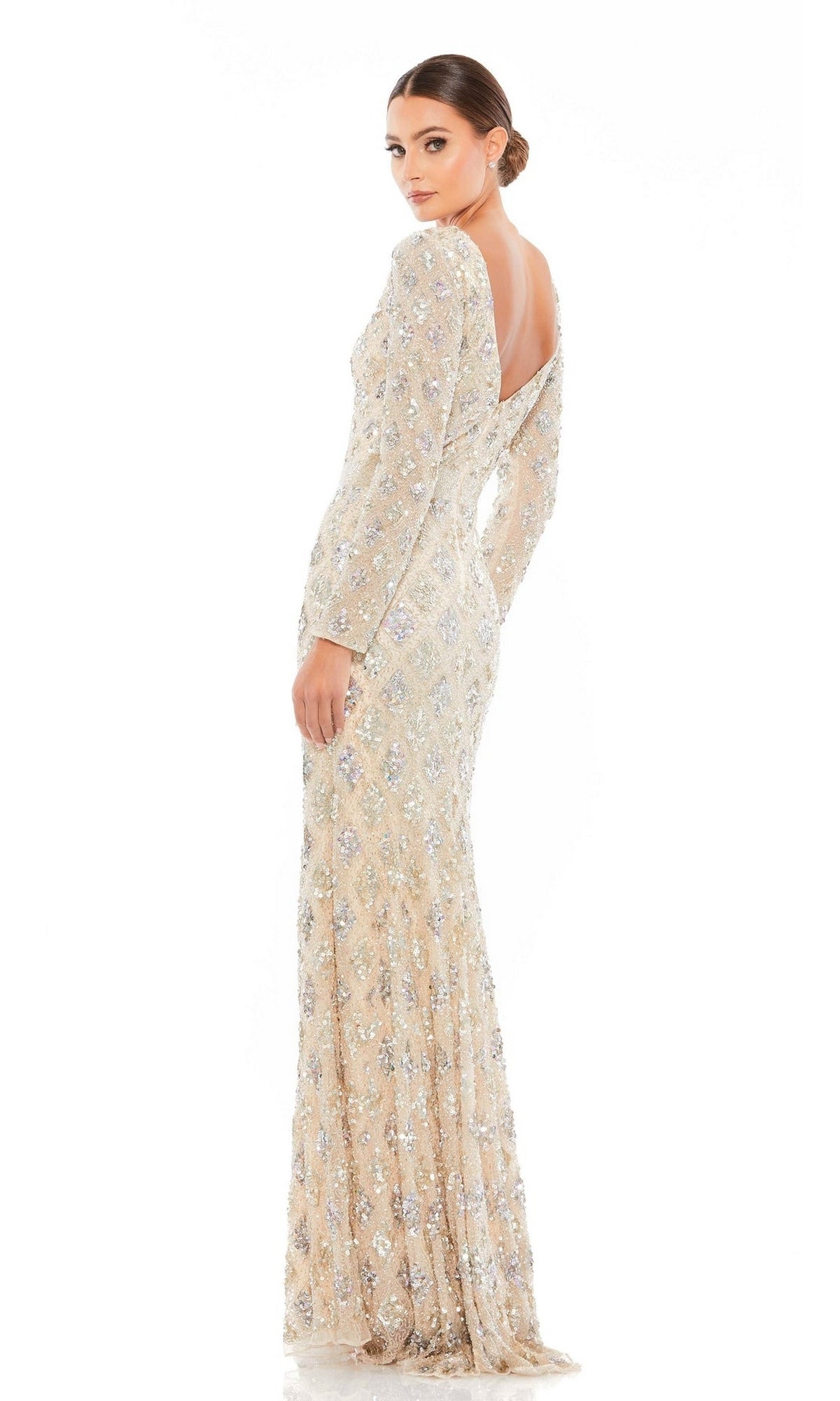 Woman poses gracefully in the Mac Duggal 5021 Long Sleeve Beaded Formal Dress, a floor-length, light-colored gown with silver sequin embellishments—an elegant choice for the sophisticated mother of the bride.